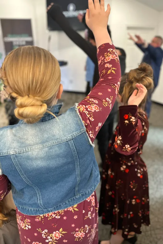 Children and adults lifting their hands in worship